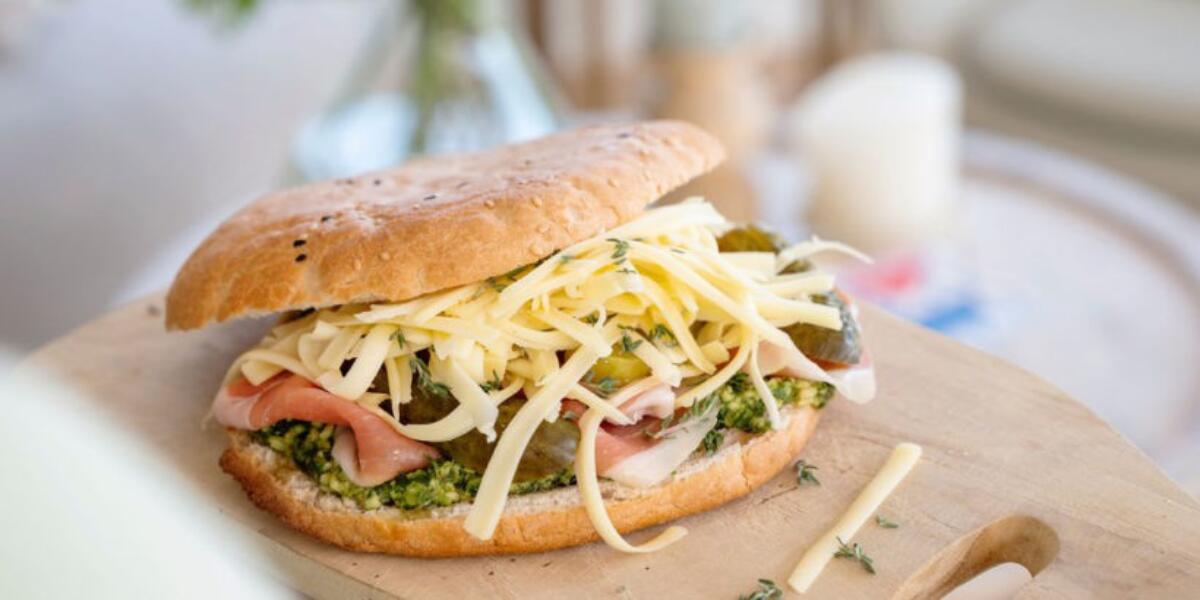 Turks brood met jonge Uniekaas, verse pesto, parmaham, rucola en pijnboompitten